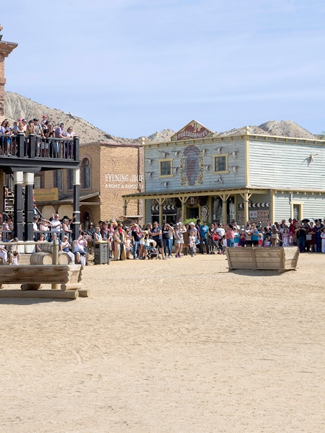 Crowd at Oasys MiniHollywood's Western town, Almería, with historic buildings and wagon.