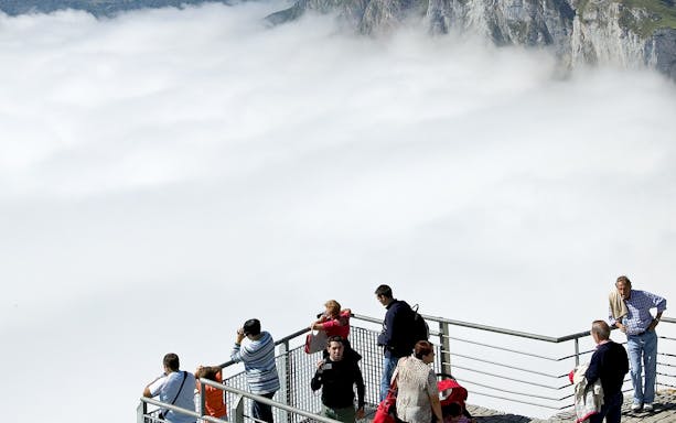 Visitors on a viewing platform above clouds at Fuente Dé Cable Car, Spain.