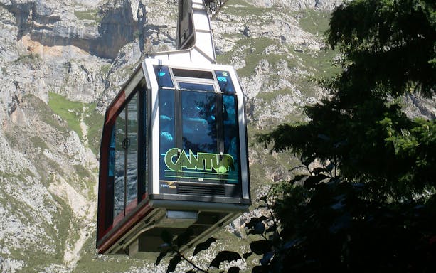 Cable car ascending Fuente Dé with mountainous backdrop.