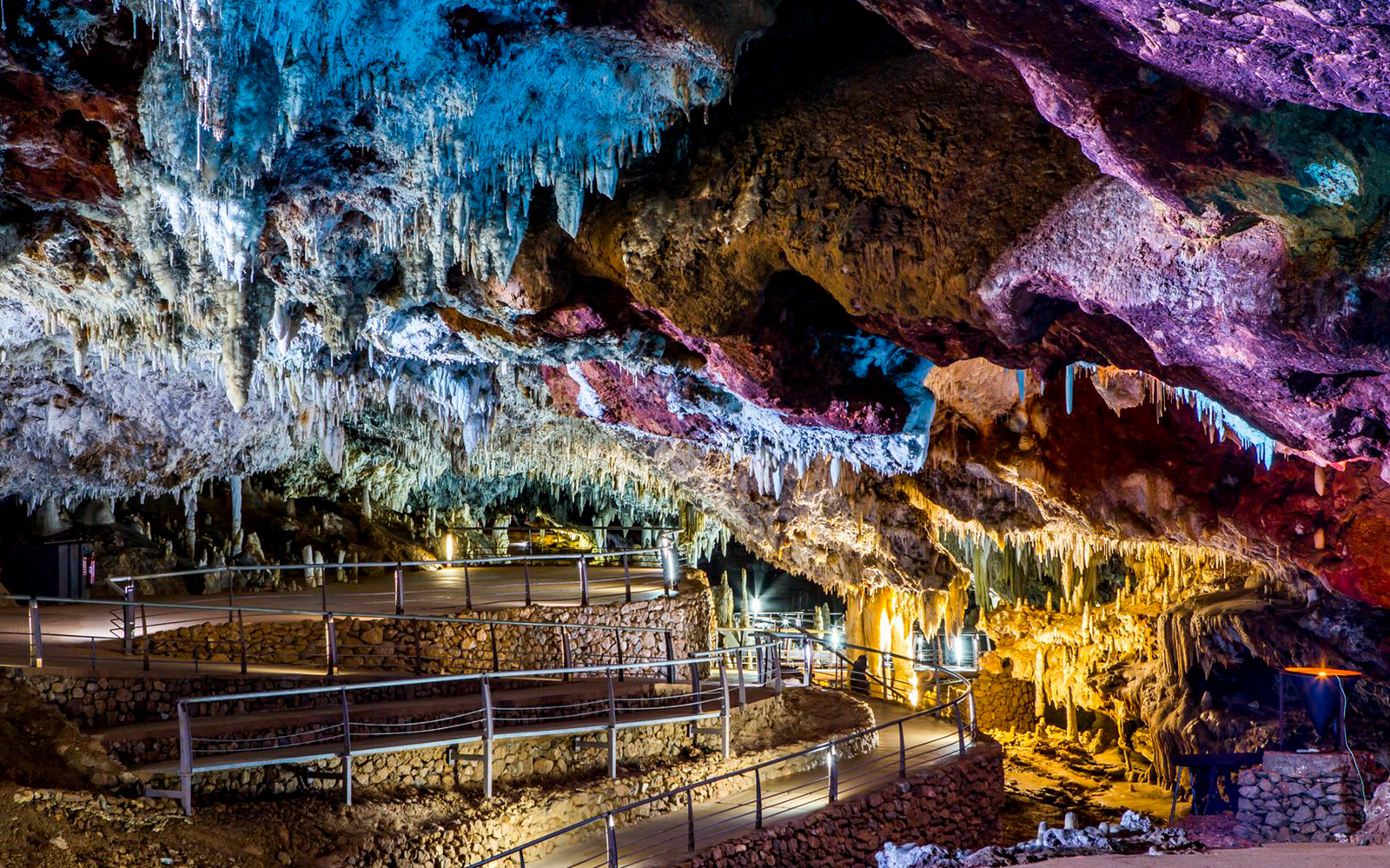 Walkway through stalactites in El Soplao Cave during guided tour.
