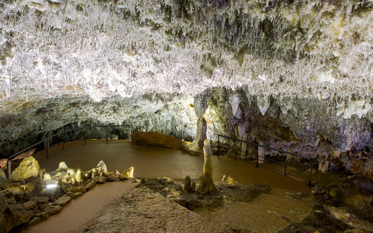 El Soplao Cave stalactites and stalagmites on guided tour path.