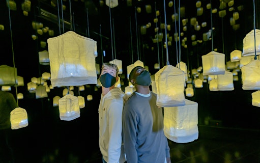 Visitors exploring illuminated lanterns at Ikono in Madrid.