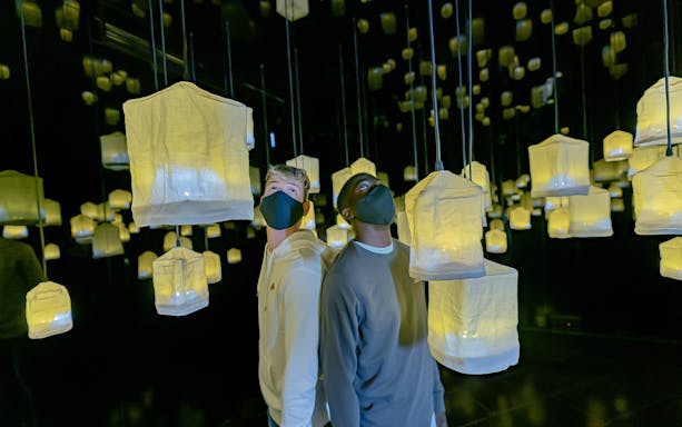 Visitors exploring illuminated lanterns at Ikono in Madrid.