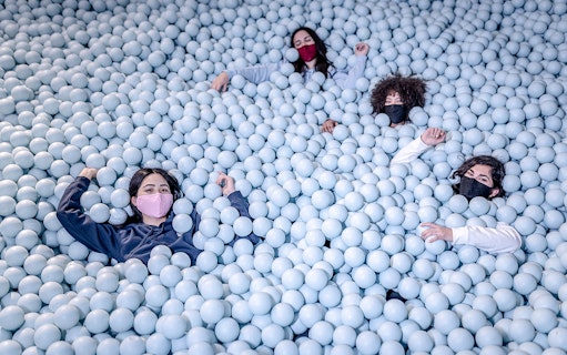 Visitors enjoying a ball pit at Ikono in Madrid.