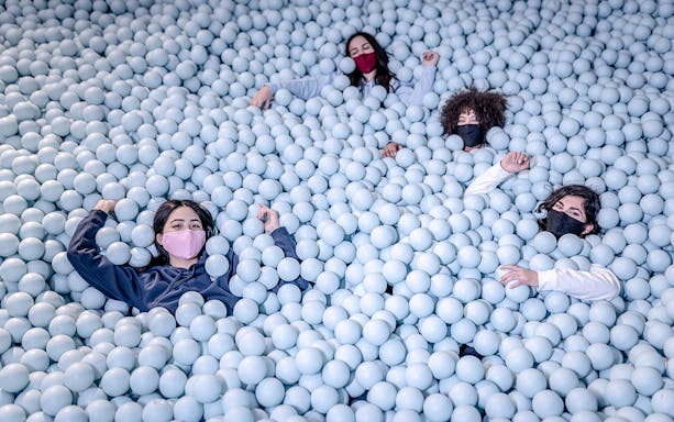 Visitors enjoying a ball pit at Ikono in Madrid.