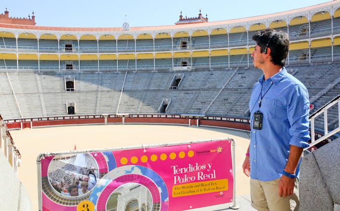 Man with audio guide at Las Ventas bullring in Madrid, viewing the arena.