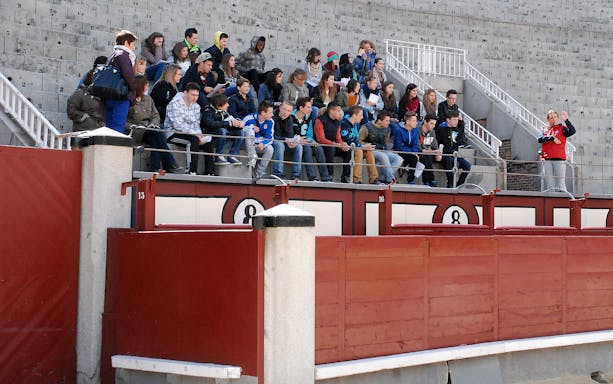 Group of tourists seated in Las Ventas bullring during a guided tour in Madrid.