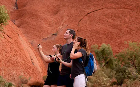 Visitors using audio guides at Uluru, Australia.