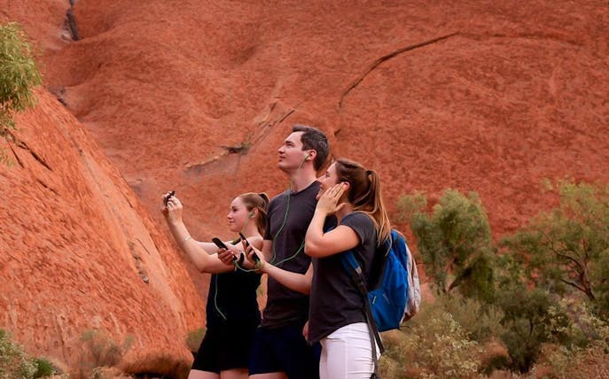Visitors using audio guides at Uluru, Australia.
