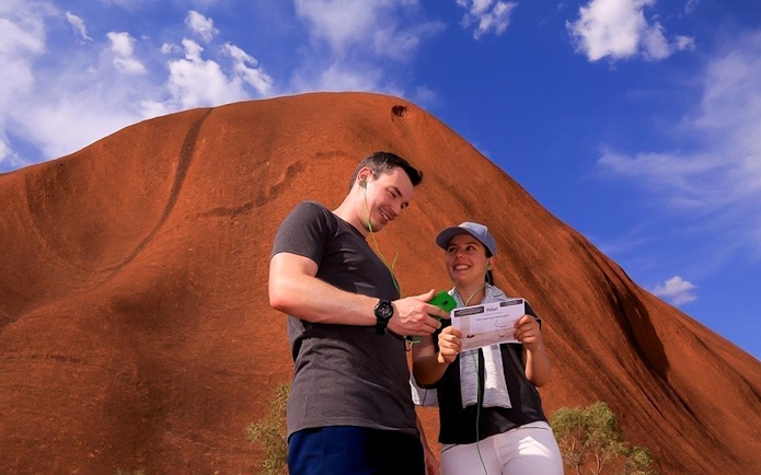 Tourists using an audio guide at Uluru, Australia.