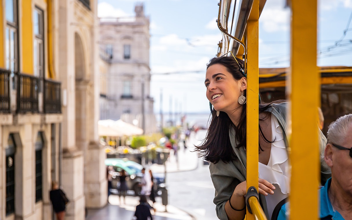 Lisbon tram tour with a woman enjoying city views.
