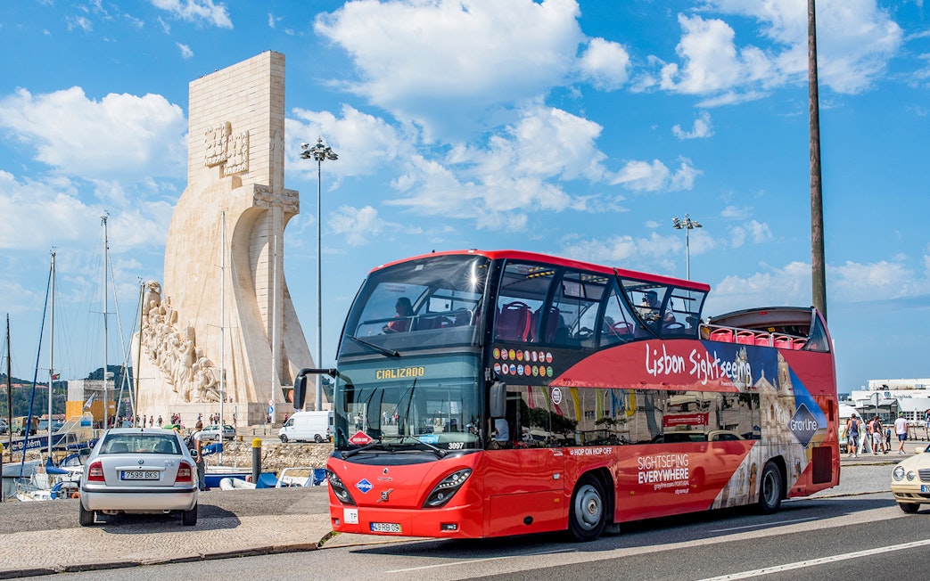 Lisbon sightseeing bus near Padrão dos Descobrimentos monument.