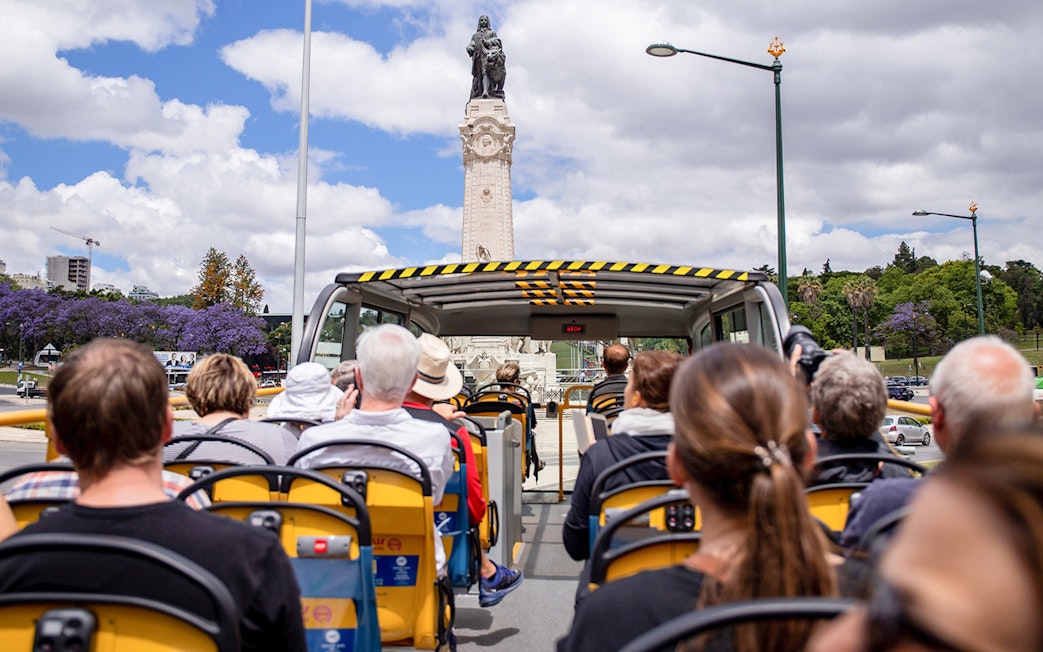 Lisbon hop-on hop-off bus approaching Marquis of Pombal Square statue.