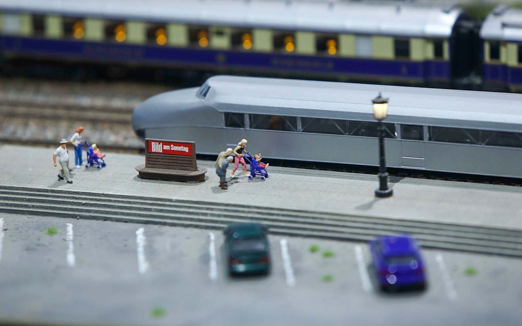 Miniature railway scene with people and strollers near a train at Hzero.