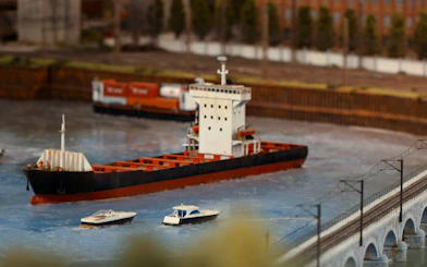Miniature cargo ship and boats on water at Hzero Railway Enterprise exhibit.