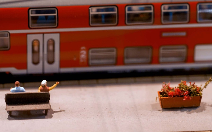 Miniature figures on a bench near a model train at Hzero Railway Enterprise.