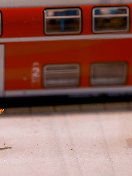 Miniature figures on a bench near a model train at Hzero Railway Enterprise.