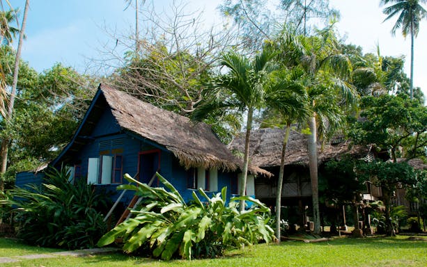Traditional wooden house surrounded by tropical plants in Langkawi.