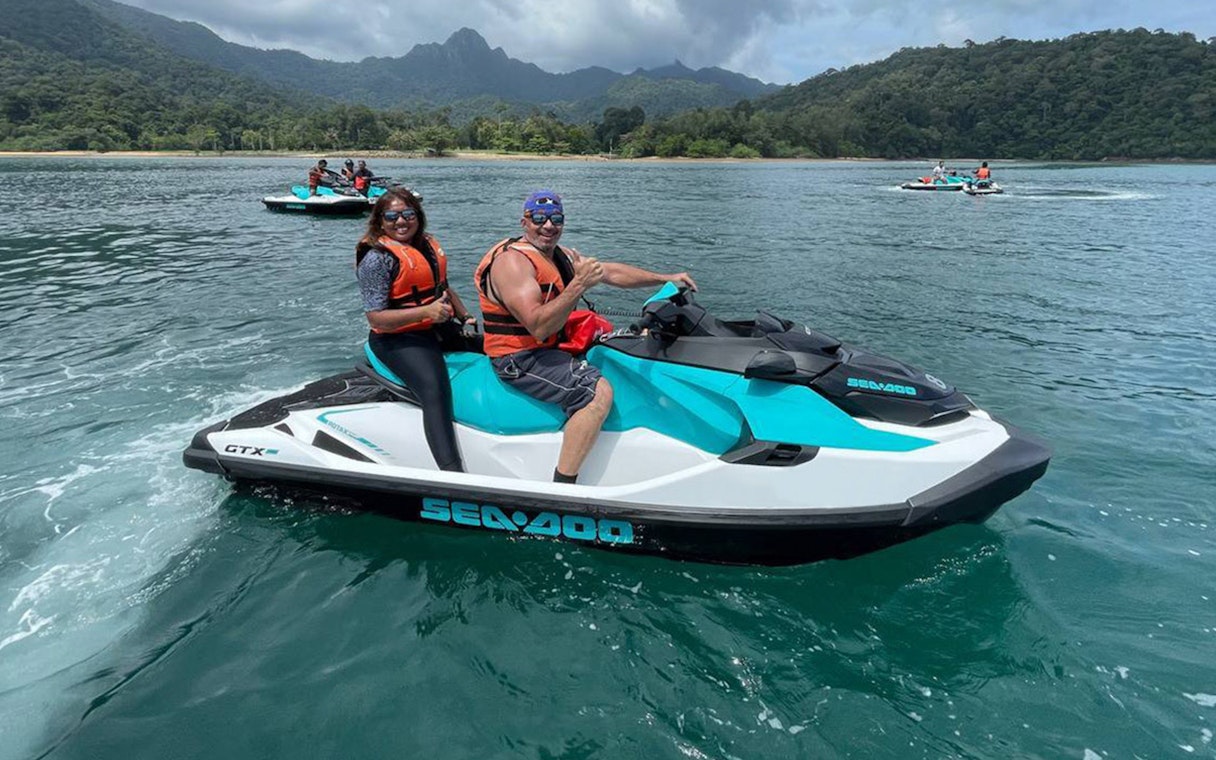 Jet skiing on turquoise waters with lush Langkawi hills in the background.