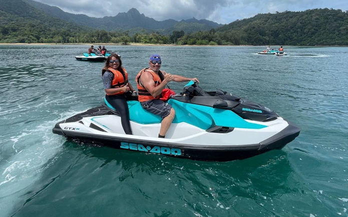 Jet skiing on turquoise waters with lush Langkawi hills in the background.