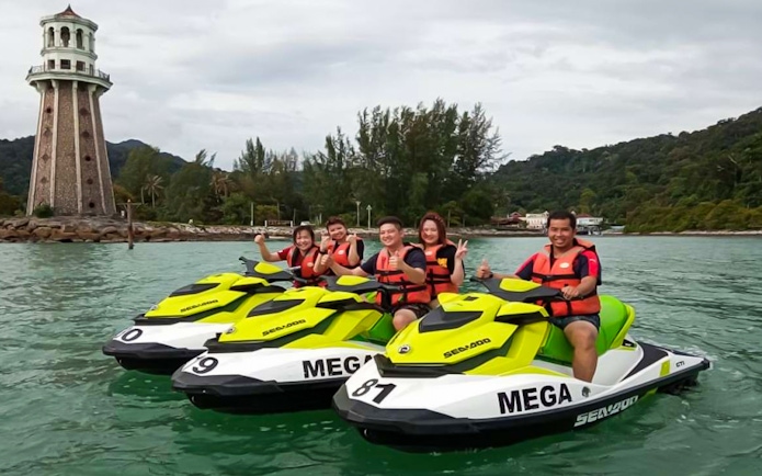 Group enjoying jet ski ride near lighthouse in Langkawi.