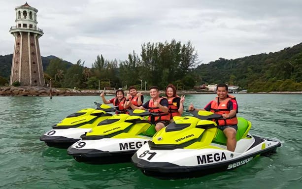 Group enjoying jet ski ride near lighthouse in Langkawi.