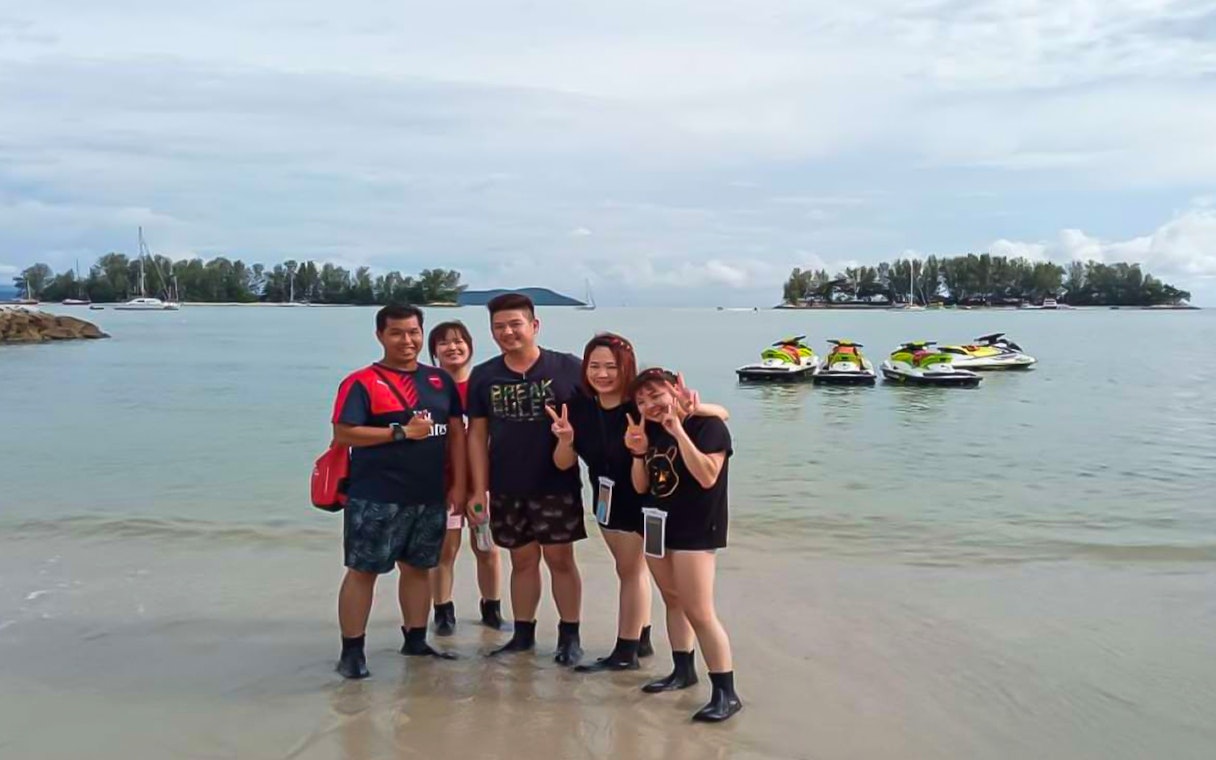 Group on beach with jet skis in Langkawi.