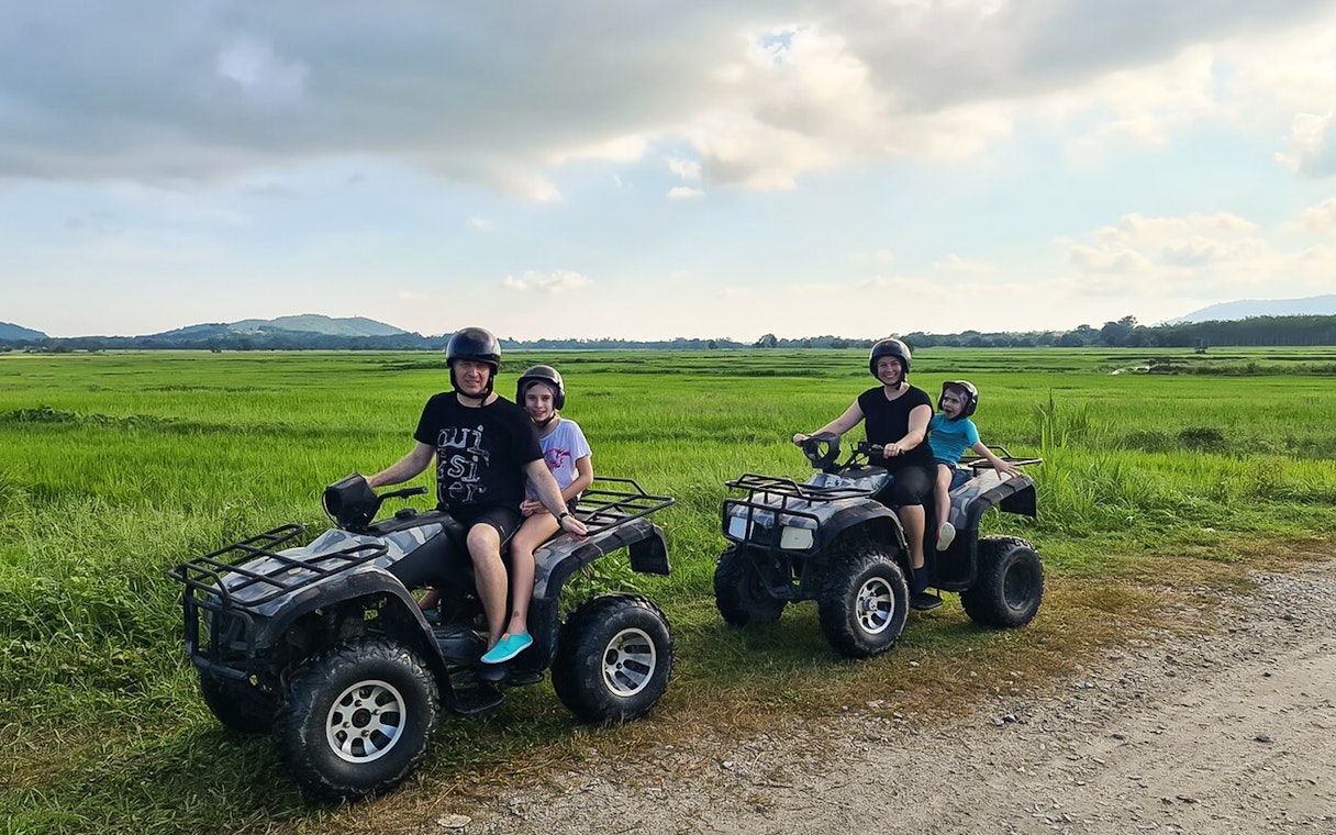ATV riders exploring lush fields on a Langkawi adventure tour.