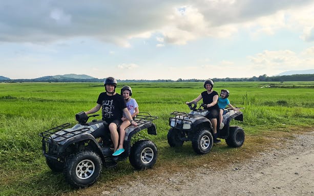 ATV riders exploring lush fields on a Langkawi adventure tour.