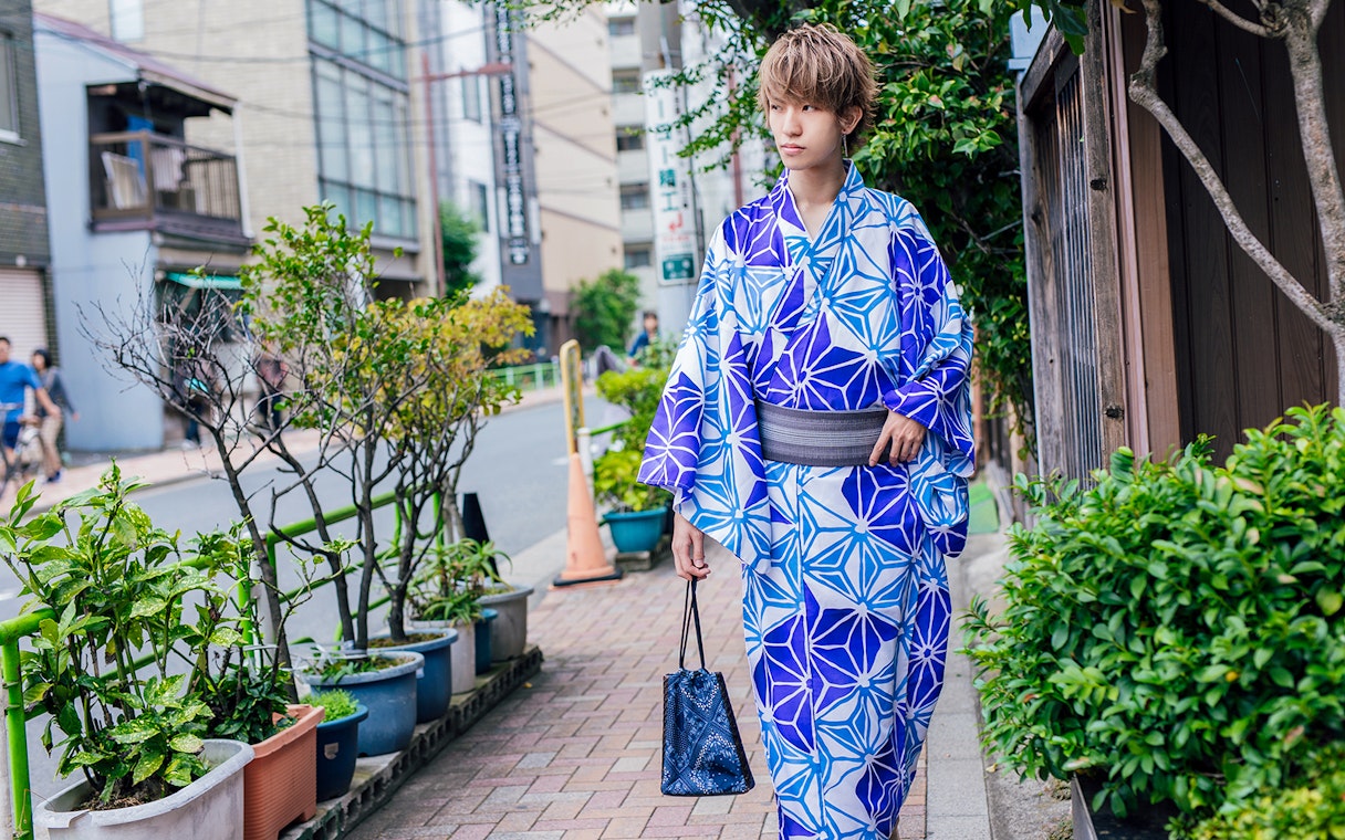 Person in blue kimono walking on a Kyoto street.
