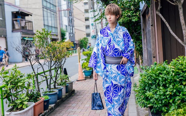 Person in blue kimono walking on a Kyoto street.