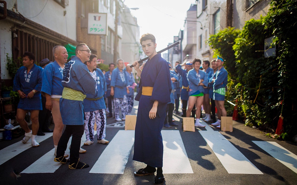 Group of people in traditional blue kimonos on a street in Kyoto.