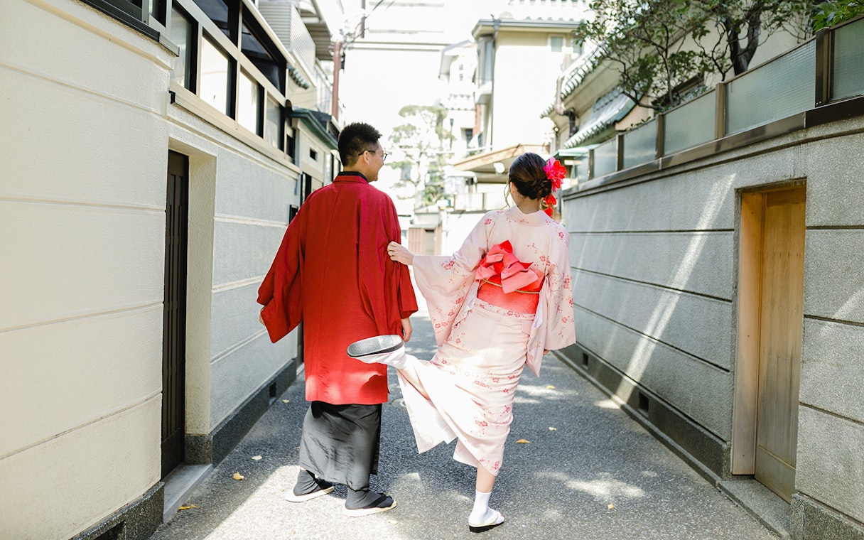 Couple in traditional kimonos walking through a narrow street in Kyoto.