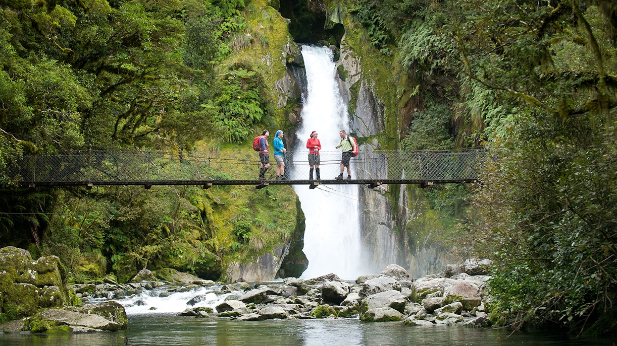 Group on bridge with waterfall view during Giant Gate Falls walking tour.