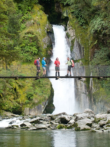 Group on bridge with waterfall view during Giant Gate Falls walking tour.