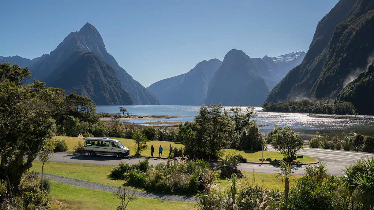 Milford Sound view with tour van and hikers on Milford Track, New Zealand.
