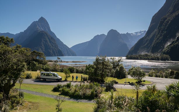 Milford Sound view with tour van and hikers on Milford Track, New Zealand.