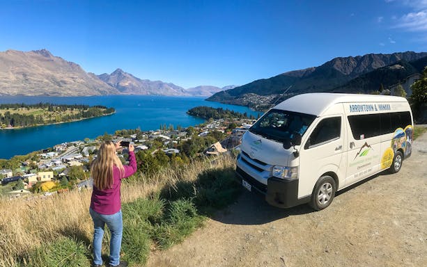 Tour van overlooking Lake Wakatipu with a person taking photos, Arrowtown to Queenstown.