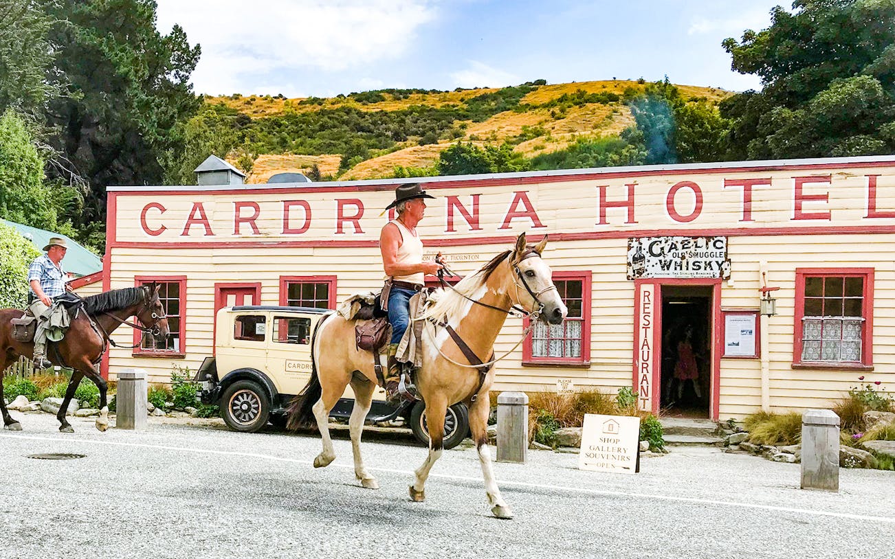 Horse riders in front of Cardrona Hotel during Arrowtown and Wanaka Highlights Tour.