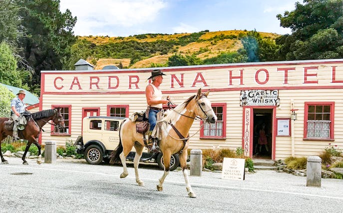 Horse riders in front of Cardrona Hotel during Arrowtown and Wanaka Highlights Tour.