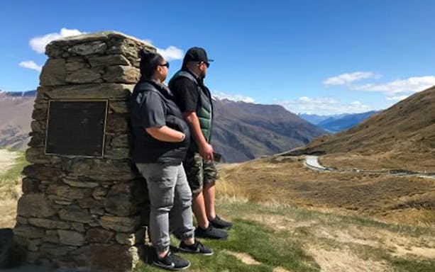 Tourists enjoying the scenic view of mountains in Arrowtown, New Zealand.