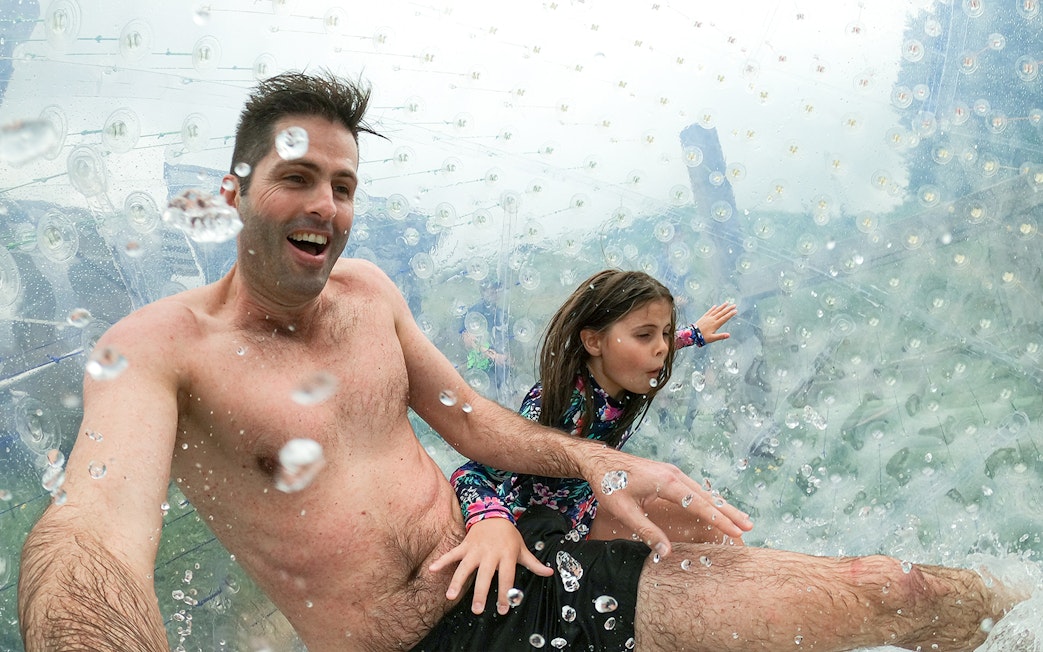 Father and daughter enjoying a Zorb giant inflatable ball ride.