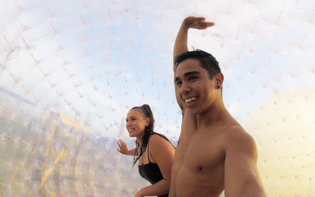 Two people inside a transparent Zorb ball enjoying the ride.
