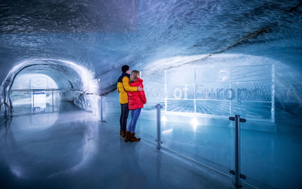 Couple exploring ice tunnel at Jungfraujoch, Switzerland.