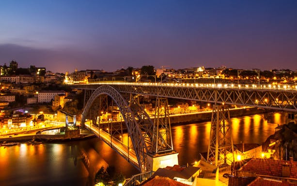 Dom Luís I Bridge illuminated at night over the Douro River in Porto, Portugal.