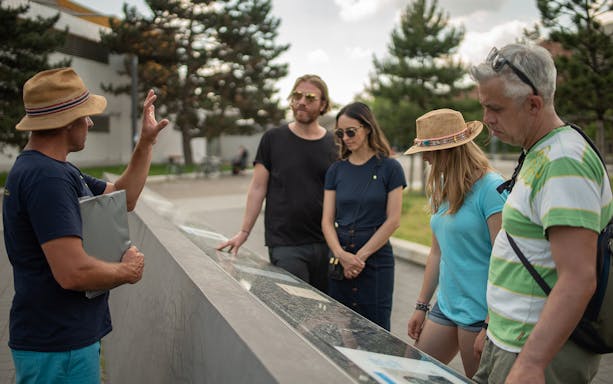 Tour guide explaining historical site to group in Berlin during Third Reich and World War II tour.