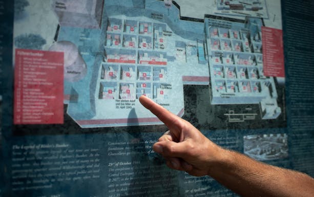 Finger pointing at a map of Hitler's bunker during a guided tour in Berlin.