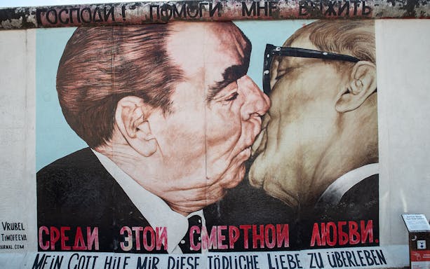 Berlin Wall mural depicting a famous Cold War-era embrace, part of the East Side Gallery tour.