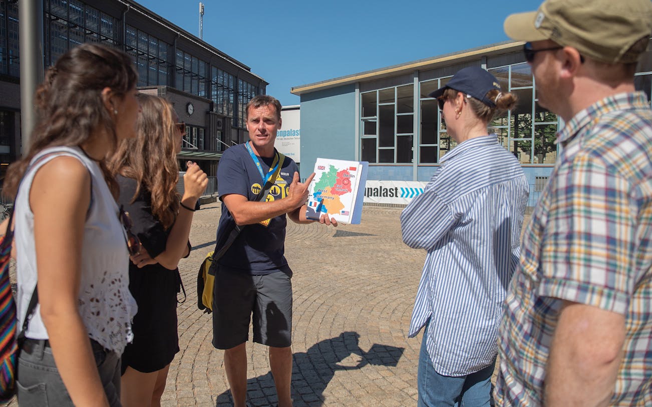 Tour guide explaining Cold War map to group in Berlin.