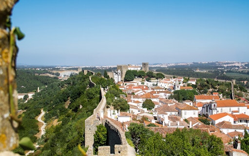 Óbidos town view with medieval walls and castle in Portugal.